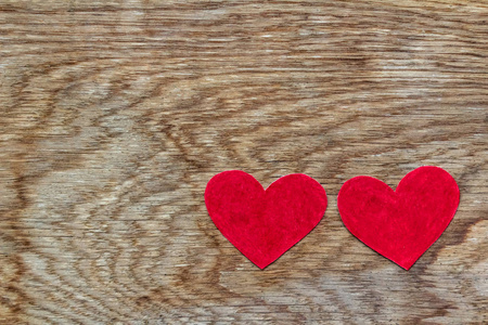 两颗红心躺在木制背景上，有复制空间