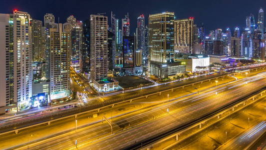 梦幻般的迪拜码头屋顶天际线。 阿拉伯联合酋长国一个大城市的摩天大楼夜间照明。 从JLT俯瞰，交通在谢赫扎耶德路