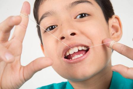 小男孩用牙线清洁牙齿