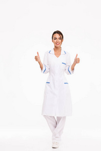 一个自信的年轻女医生穿着制服，站在白色背景上，竖起大拇指