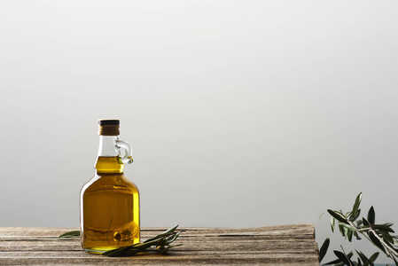 油瓶和分离在灰色上的橄榄树叶