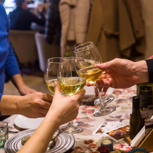 在一家餐馆里，一群朋友或家人正在吃晚饭的时候，酒杯中的白葡萄酒