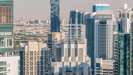 迪拜码头和JLT摩天大楼在日落时分的空中天际线。 多个最高塔的伟大视角。 阳光洒在建筑物上。 阿拉伯联合酋长国。