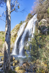 瀑布和池塘的侧视图在它前面在秋天山植被之中
