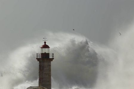 暴风雨的海浪飞溅和喷雾。 柔和的背光。 奥波托旧灯塔。