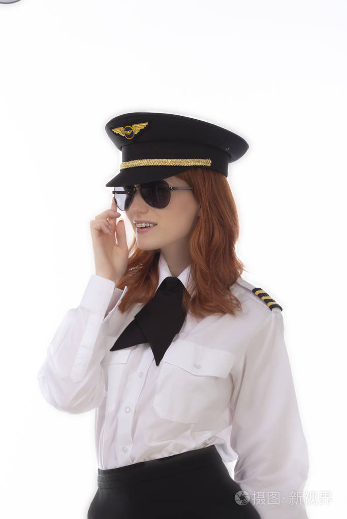 年轻的女飞行员红头发身穿制服戴着帽子