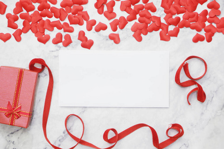 平躺情人节背景空白纸为您的短信在桌子周围与红色礼品盒红色丝带和小心形。