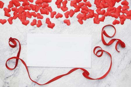 平躺情人节背景空白纸为您的短信在桌子周围与红色丝带和小心脏形状。