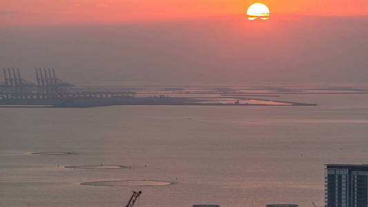 日落飞越蓝水岛空中时间。 手掌杰贝尔阿里在背景上。 太阳映在水面上