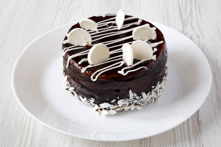 自制巧克力樱桃蛋糕在盘子上的白色木制表面侧面视图。 快关门。