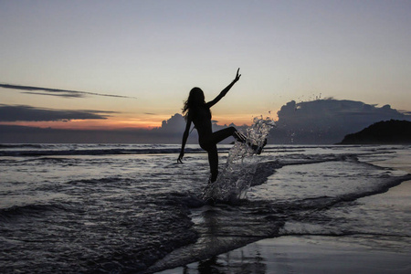 海滩上夕阳背景下的女孩剪影