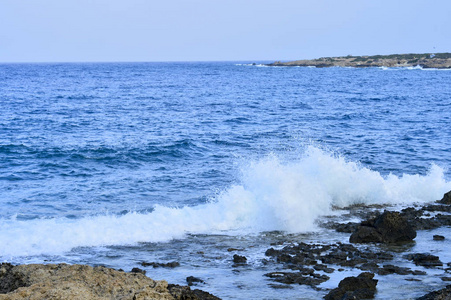 在海浪中被遗弃的岛岸。 背景。