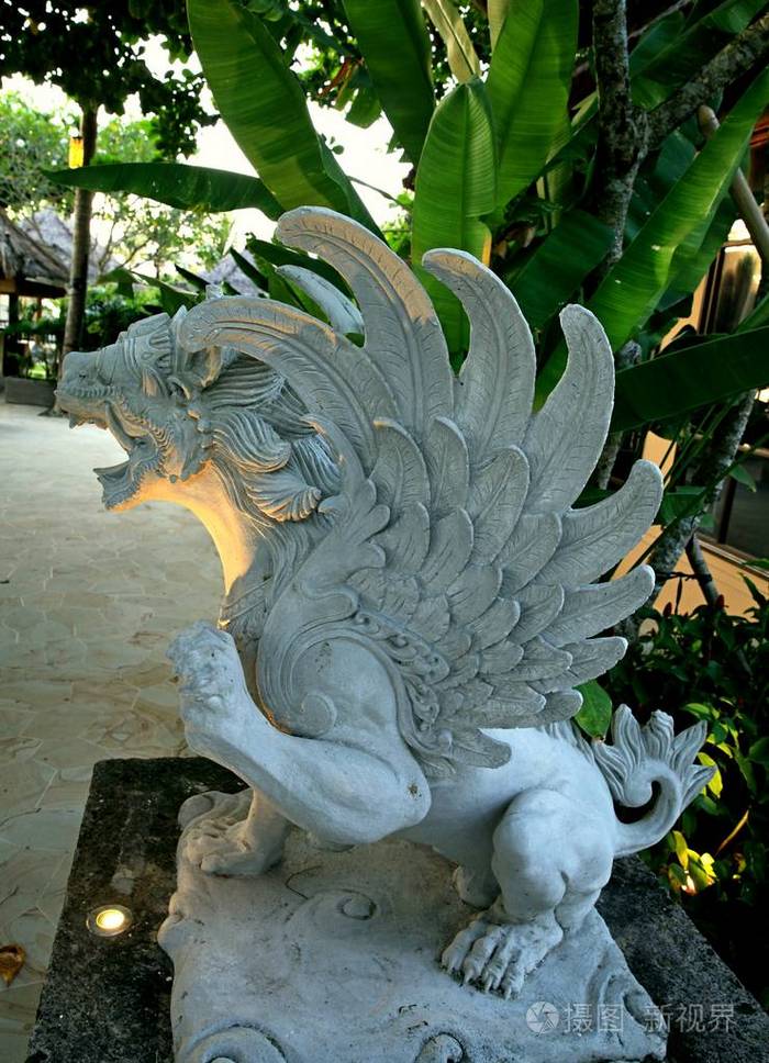 神话中的狮子雕像翅膀坐在三条腿上有一个凸起的爪巴厘岛印度尼西亚