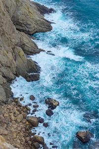 蓝色的水。 岩石海岸。 水面的纹理。 海浪拍打着岩石。 悬崖。 黑海。 巴拉克拉瓦堤。 雅尔塔。 在克里米亚休息。 沿着海滩散步