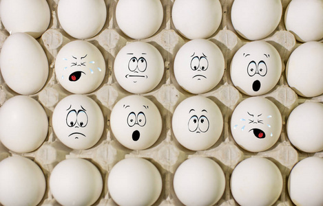 鸡蛋有脸,鸡蛋看起来有戏剧性的面部表情在煮熟的鸡蛋上. 一包鸡蛋.
