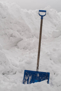 雪铲卡在一堆雪山上。