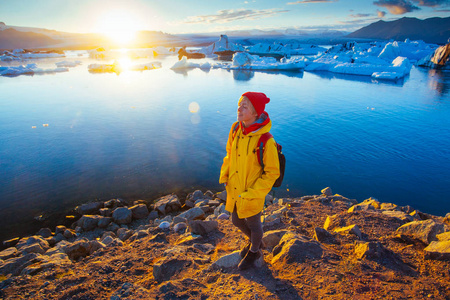 冰岛冰川泻湖附近穿着亮黄色雨衣的女人