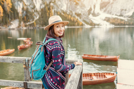 在意大利多洛米斯阿尔卑斯山著名旅游湖布莱斯岸边的亚洲女性旅行者。秋天的时候，在山上旅行和冒险的概念