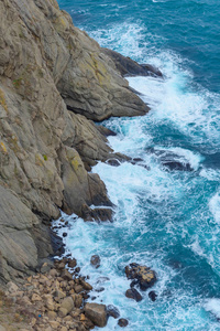 蓝色的水。洛基海岸。水面的纹理..波浪在岩石上跳动。克里夫。黑海。巴拉克拉瓦的堤岸。雅尔塔。在克里米亚休息。沿着海滩散步。旅游业