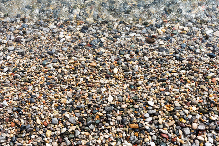不同大小和颜色的湿海卵石石头和水的背景