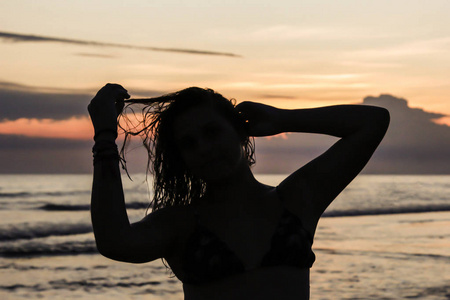 沙滩上夕阳背景下的女孩剪影