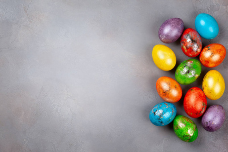 复活节的概念是五颜六色的复活节彩蛋在灰色背景。 顶部视图与复制空间。