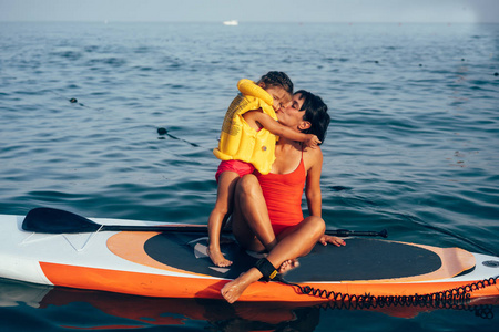 母亲带着女儿在划桨板上