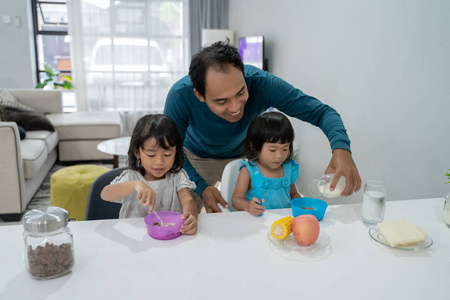 亚洲爸爸与他的两个小女孩吃早餐