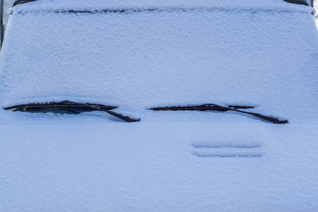 汽车的前部被白雪覆盖，只能显示车窗雨刷寒冷的冬季天气状况