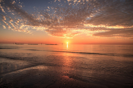 佛罗里达南马科岛海滩，夕阳下的红橙色天空下的波浪涟漪