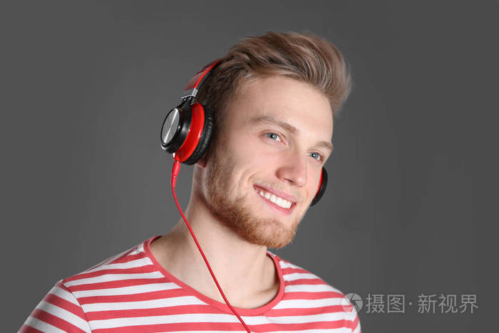 带着耳机在彩色背景下听音乐的帅哥