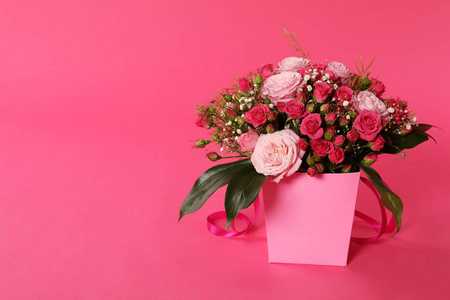漂亮的花束在彩色背景上的纸礼品盒里。 文本空间