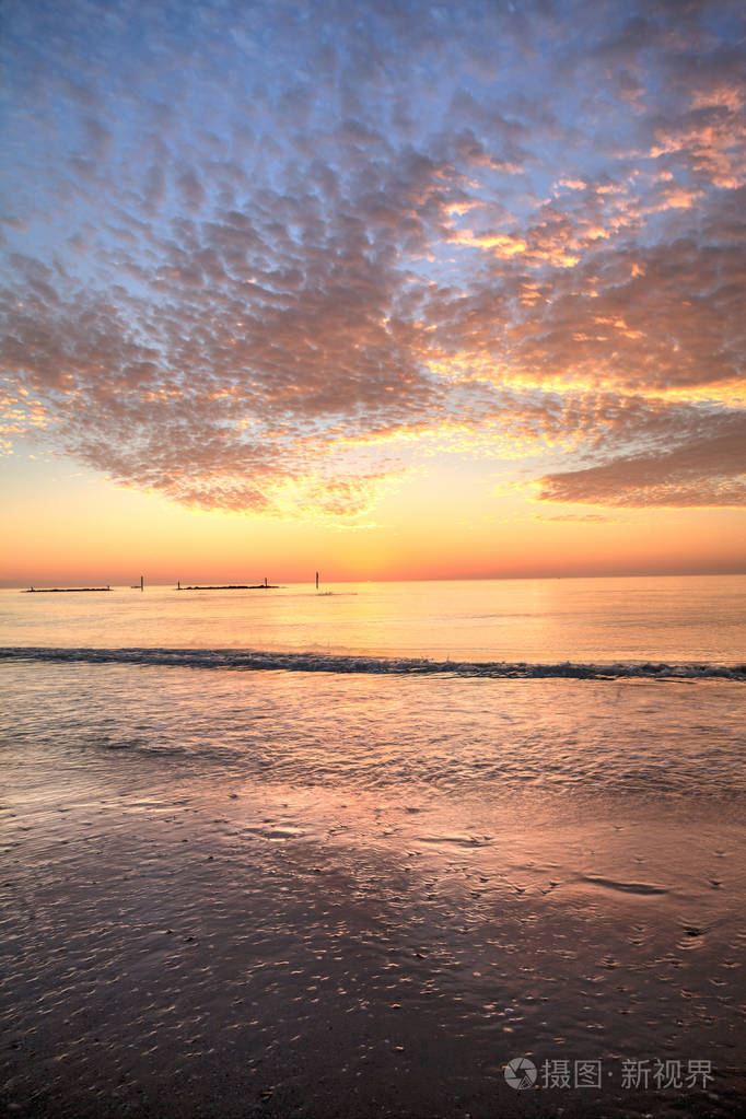 佛罗里达南马科岛海滩夕阳下的红橙色天空下的波浪涟漪