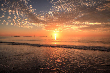 佛罗里达南马科岛海滩，夕阳下的红橙色天空下的波浪涟漪