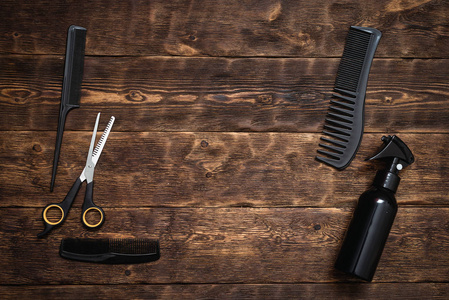 一种各种美发工具,如牙刷喷雾器和木板上的剪刀.照片