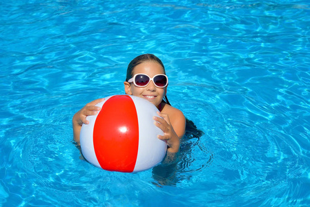 真正可爱的女孩在游泳池放松，暑假概念