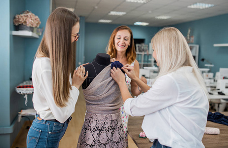 三个漂亮的女人正在缝制一个结的衣服