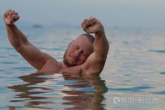 晒黑的男人,裸体的躯干摆在海边