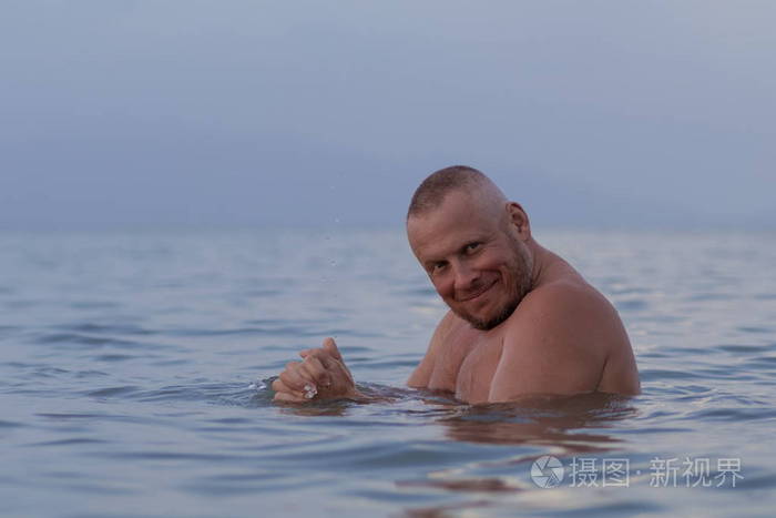 晒黑的男人,裸体的躯干摆在海边