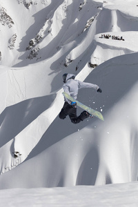 滑雪者在雪坡的背景下飞行。极限冬季运动, 滑雪板运动