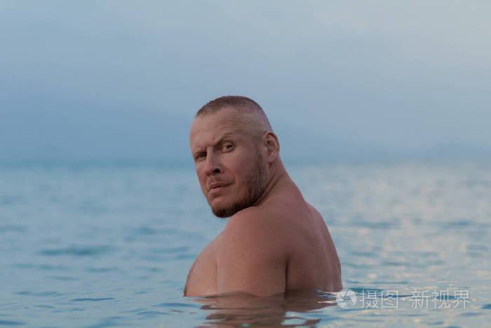 晒黑的男人,裸体的躯干摆在海边