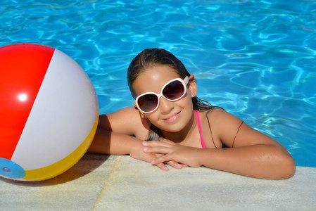 真正可爱的女孩放松游泳池暑假概念
