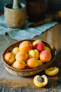 新鲜的杏子放在篮子里，放在木桌上，穿着乡村风格