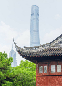 上海市中心摩天大楼的风景和中国传统建筑的黑色弯曲向上的屋顶在旧城。 上海是亚洲受欢迎的旅游目的地。