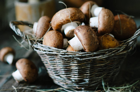 木制桌子上篮子里的棕色蘑菇，乡村风格