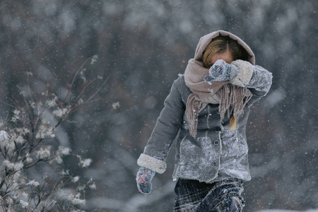 可爱的小女孩在树林里的冬天。下雪