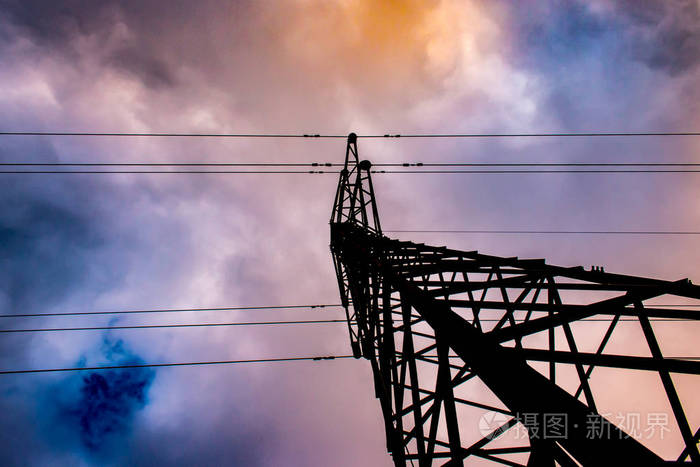 带有电力线路的电力线塔的镜头。在哈钦森堪萨斯乌萨以西的蓝天和五颜六色的云。就在公园对面