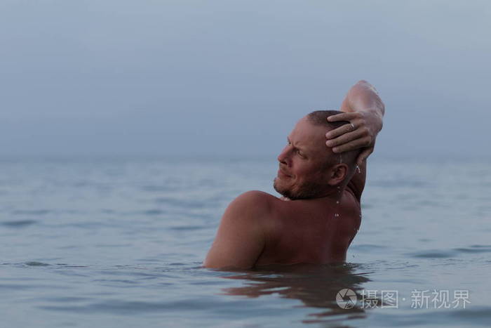 晒黑的男人,裸体的躯干摆在海边