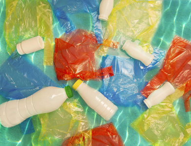 五颜六色的包装和白色塑料瓶在海水中。污染概念。