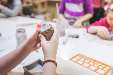 有创造力的孩子在陶器车间用粘土工作.照片